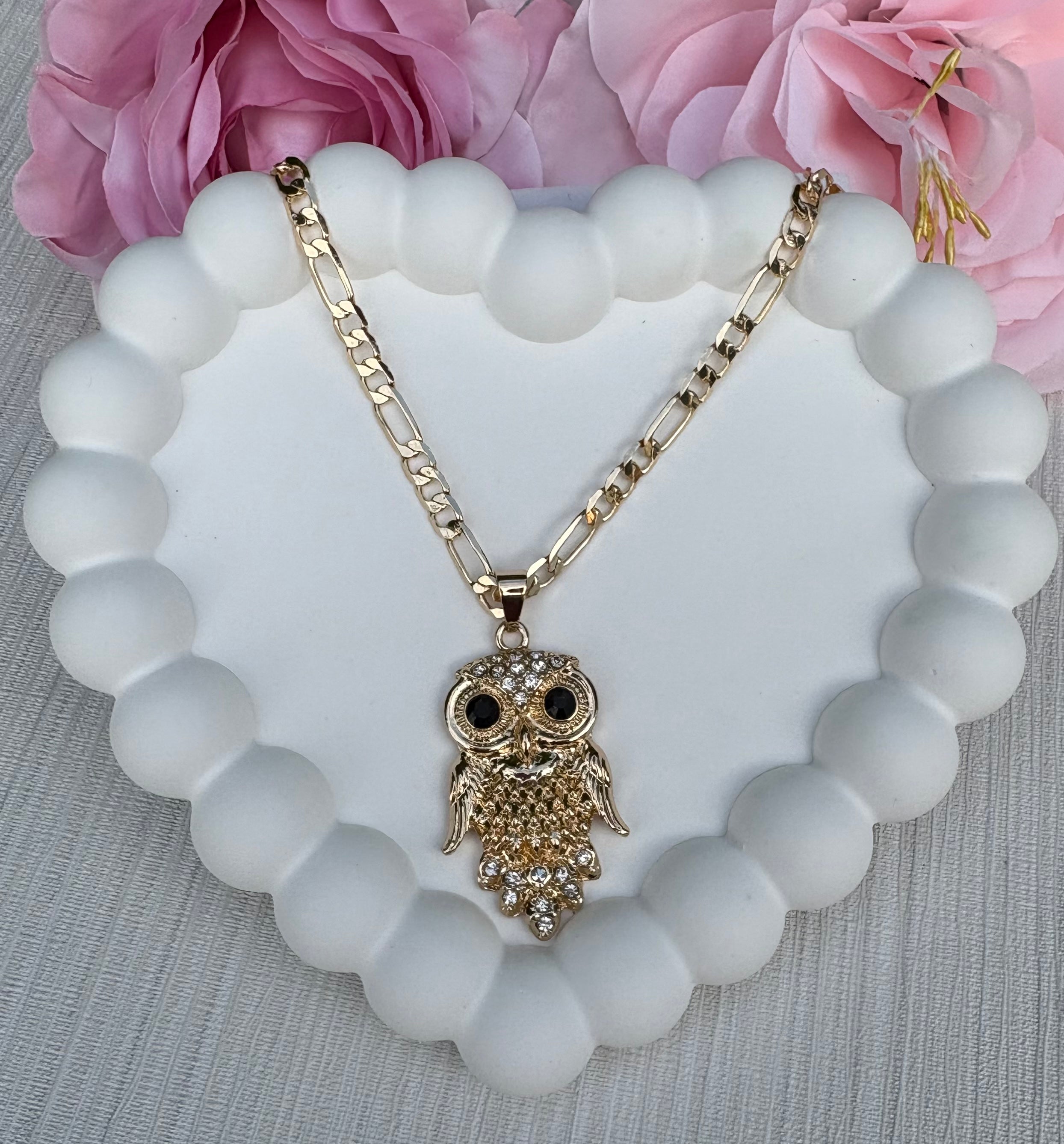 Gold owl necklace with black gemstone eyes on a Figaro chain, displayed on white background.