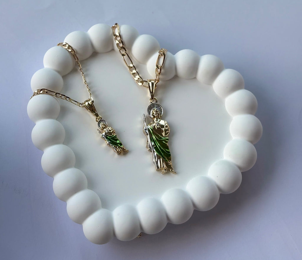 San Judas Tadeo Figaro Necklace with small and large pendants, displayed on a white beaded heart tray.