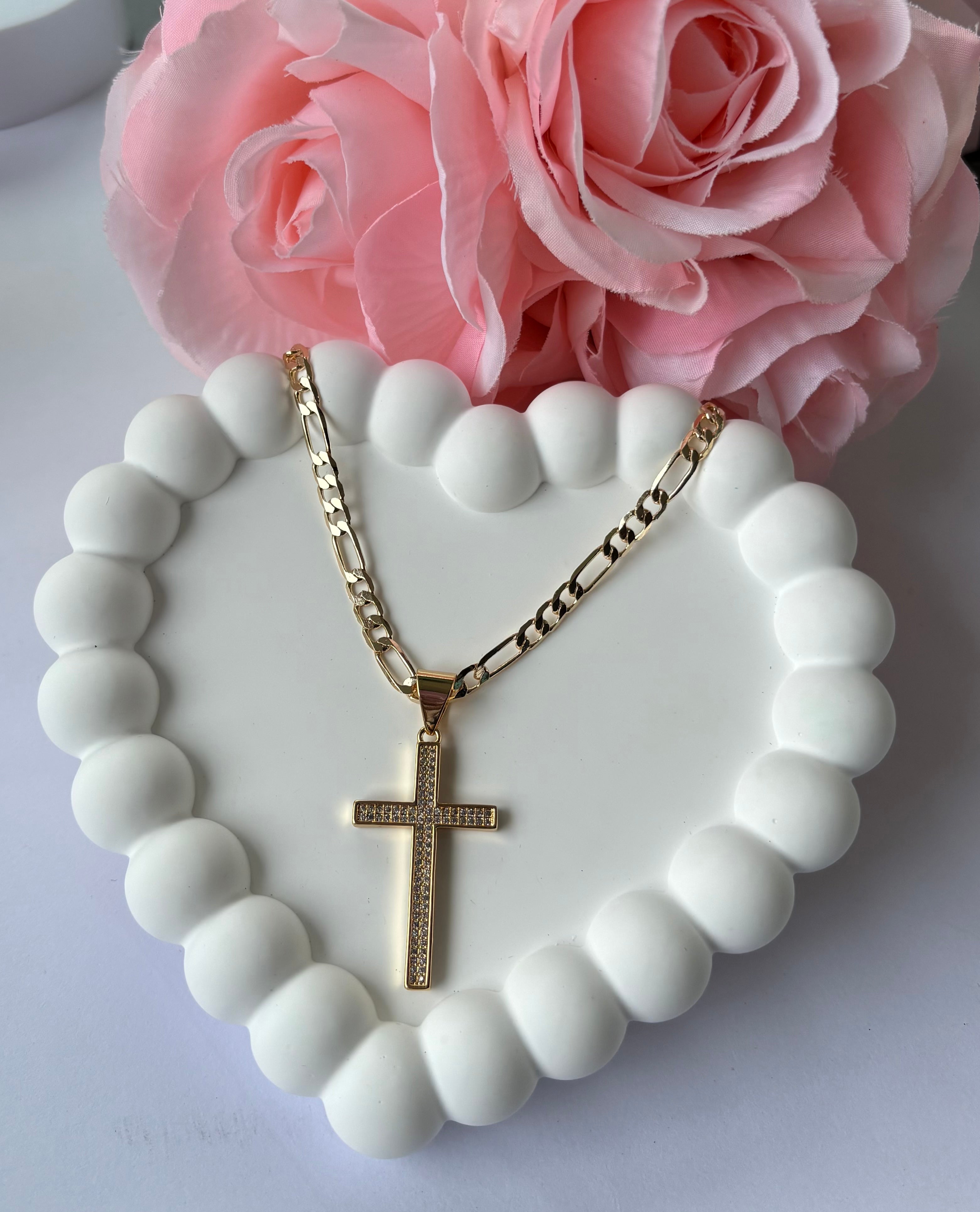 Gold plated Classic Cross Necklace with sparkling details, displayed on a white beaded heart tray with pink roses.